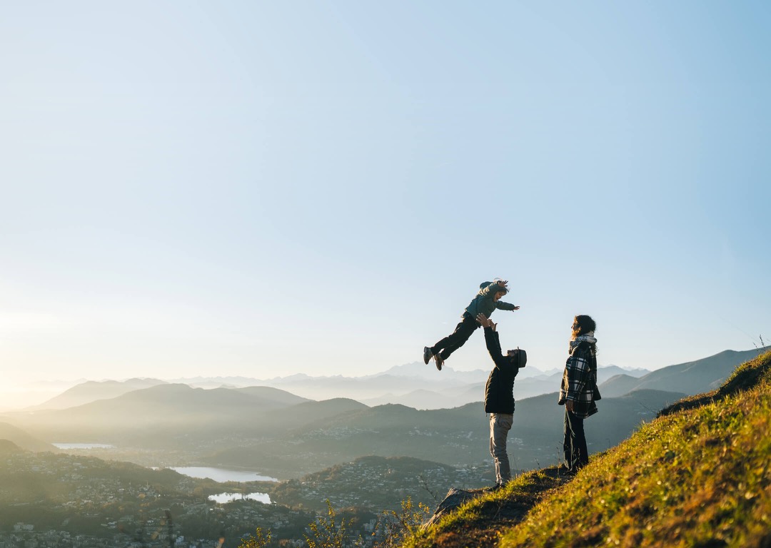 Familia caminando por un paisaje montañoso al amanecer